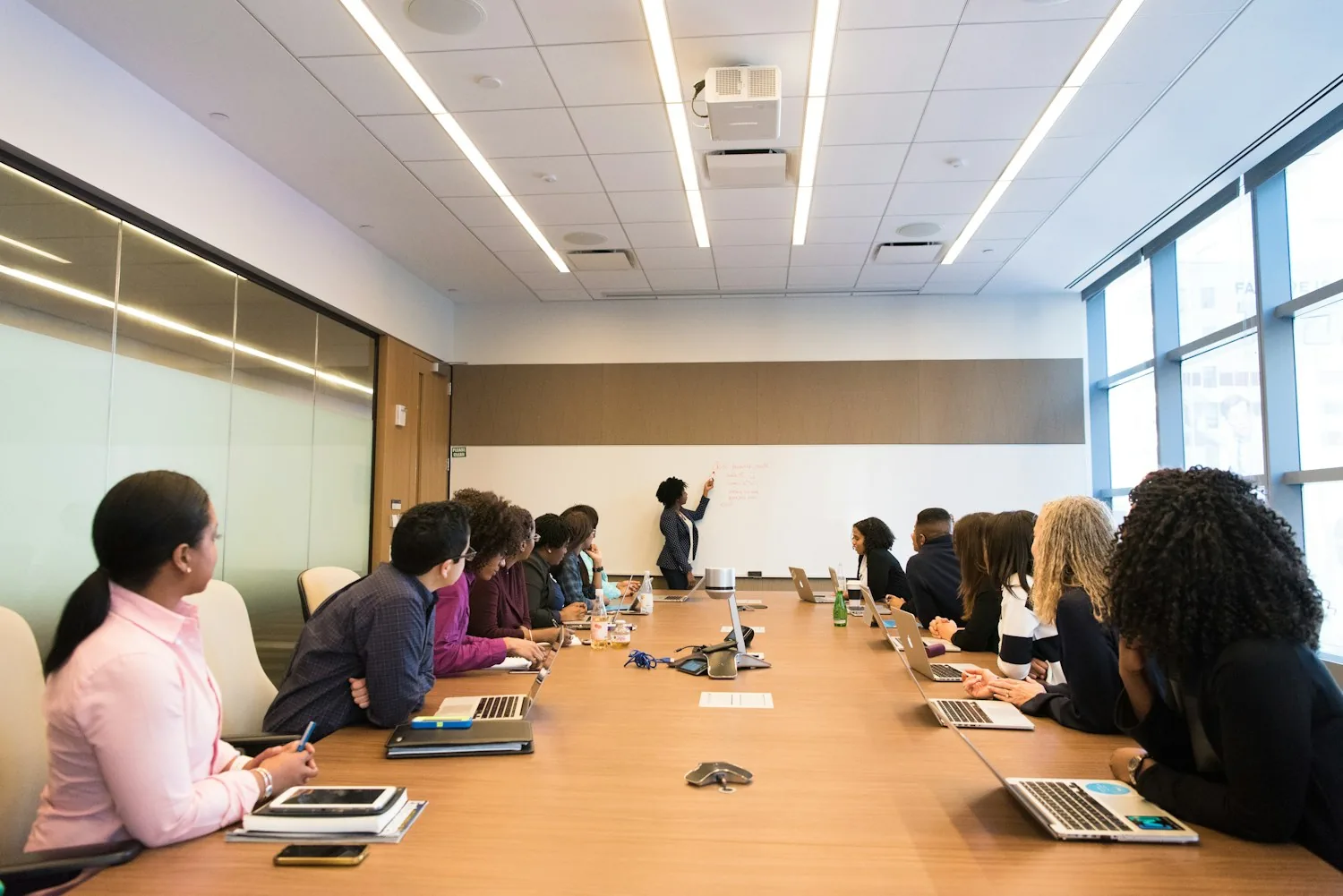 A facilitator leads a collaborative learning session around a conference table.